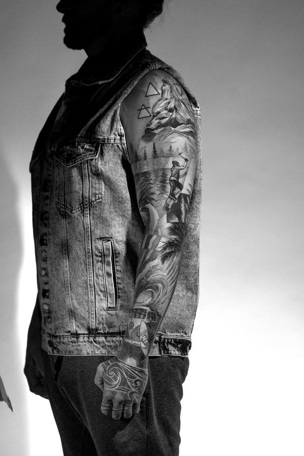 Arm-Tattoo mit den vier Elementen in Schwarz und Grau