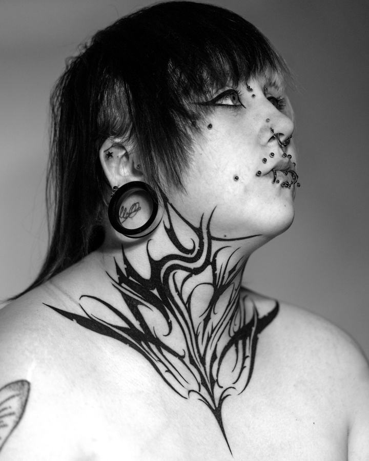 Tribal-Tattoo an Hals und Brust in Schwarz